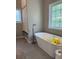 Bright bathroom featuring a stylish freestanding tub, walk in shower, and a large window at 8701 Caspiana Ln, North Charleston, SC 29420
