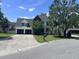 Inviting two-story home with a landscaped front yard, mature trees, and a two-car garage at 8701 Caspiana Ln, North Charleston, SC 29420