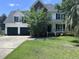 Charming two-story home featuring a manicured lawn, attached two car garage, and traditional architectural details at 8701 Caspiana Ln, North Charleston, SC 29420
