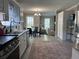 Open-concept kitchen with stainless appliances and granite countertops, flowing into the dining area and cozy living space at 8701 Caspiana Ln, North Charleston, SC 29420