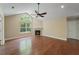 Spacious living room featuring a cozy fireplace, ceiling fan, and hardwood floors with a large window at 8800 Dorchester Rd # 4001, North Charleston, SC 29420