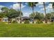 Expansive backyard with a swimming pool, lush greenery, and palm trees, creating a private oasis at 902 Mikell Dr, Charleston, SC 29412