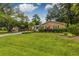 Inviting brick home with a lush green lawn, complemented by mature trees and vibrant landscaping at 902 Mikell Dr, Charleston, SC 29412