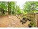 Green backyard with a wooden fence, mature trees, and plenty of potted plants, perfect for gardening at 9887 Midview Dr, Ladson, SC 29456