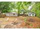 Spacious backyard with scattered foliage, mature trees, and a view of the brick house and detached building at 9887 Midview Dr, Ladson, SC 29456