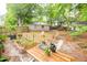 Large backyard with mature trees, wooden fence, garden beds, and wooden table and chairs for outdoor enjoyment at 9887 Midview Dr, Ladson, SC 29456