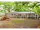 Back exterior view of a brick house, showcasing the screened-in porch with foliage scattered around at 9887 Midview Dr, Ladson, SC 29456