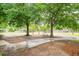 Lush green front lawn featuring mature trees, offering shade and curb appeal to the property at 9887 Midview Dr, Ladson, SC 29456