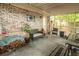 Covered patio with brick wall and cushioned furniture for a relaxing outdoor space at 9887 Midview Dr, Ladson, SC 29456