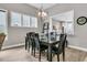 This dining room features a modern chandelier, a stylish table with seating for six, and three well-lit windows at 1011 Old Field Dr, Summerville, SC 29483