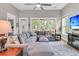 Spacious living room with large sectional, ceiling fan, and many windows overlooking the backyard at 1011 Old Field Dr, Summerville, SC 29483