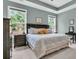 Spacious main bedroom with neutral carpet, tray ceiling, and generous natural light from windows and tasteful decor at 1011 Old Field Dr, Summerville, SC 29483