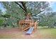 Unique wooden treehouse structure with multiple levels, stairs, and a slide, nestled in a large tree at 1011 Old Field Dr, Summerville, SC 29483