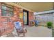 Covered patio with chairs, wood pile, and views of the brick exterior at 1019 Tj Ln, Summerville, SC 29486
