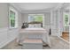 Bright bedroom with a queen size bed, large window with white trim, and decorative wainscoting at 1023 Shelley Rd, Charleston, SC 29407