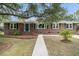Classic brick home with black shutters, a neatly landscaped yard, and a concrete walkway at 1023 Shelley Rd, Charleston, SC 29407