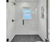 Luxurious walk-in shower featuring white subway tile, modern fixtures, glass door, and niche shelving at 1023 Shelley Rd, Charleston, SC 29407