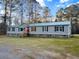 Lovely house with a green metal roof, set on a lush green lawn at 107 Bessie Ln, Bonneau, SC 29431