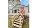 Charming home featuring a red front door, quaint window, and wooden stairs at 107 Bessie Ln, Bonneau, SC 29431