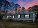 Exterior view of a home at twilight, with a green roof at 107 Bessie Ln, Bonneau, SC 29431