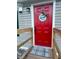 Close-up of the red front door with welcome mat and home sweet home decoration at 107 Bessie Ln, Bonneau, SC 29431