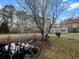 Residential view of a charming home accented by a blossoming tree, pump, and a tranquil pond in the front yard at 107 Bessie Ln, Bonneau, SC 29431