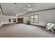 Spacious living room with large windows, neutral colored carpet, ceiling fans, and a fireplace at 107 Bessie Ln, Bonneau, SC 29431