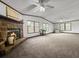 Spacious living room with large windows, neutral colored carpet, ceiling fans, and a fireplace at 107 Bessie Ln, Bonneau, SC 29431