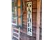 Close-up of wooden cabin wall with a weathered 'Gather Here' sign and rustic charm at 107 Bessie Ln, Bonneau, SC 29431