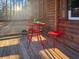 Cozy cabin porch with a charming red bistro set and sunlight streaming through the trees at 107 Bessie Ln, Bonneau, SC 29431