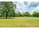 Picturesque view of the expansive green grounds with mature trees and a sunny sky at 1100 Cass Dr, Moncks Corner, SC 29461