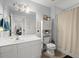 This bathroom offers great lighting, a vanity, toilet, shelving, and shower with curtain at 115 S Ainsdale Dr, Charleston, SC 29414