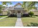 Charming two-story home featuring a welcoming front porch with white railings and a well-maintained lawn at 115 S Ainsdale Dr, Charleston, SC 29414