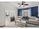 Comfortable living room with a cozy sectional sofa, stylish blue accent wall, and bright natural light at 115 S Ainsdale Dr, Charleston, SC 29414