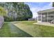 A spacious backyard with a screened porch and a view of the trees and neighborhood at 118 Beacon Falls Ct, Summerville, SC 29486