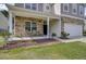 Inviting front porch with stone detailing, comfortable seating, and manicured landscaping at 118 Beacon Falls Ct, Summerville, SC 29486