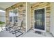 Close-up of a welcoming front porch with seating, stone accents, and a stylish entrance door at 118 Beacon Falls Ct, Summerville, SC 29486
