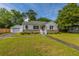 Charming home features a detached garage, green lawn, and inviting front porch at 1226 Forestwood Dr, Charleston, SC 29407