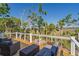 Relax on the spacious deck with wicker furniture, overlooking serene marsh views and a cozy fire pit area at 123 Jungle Rd, Edisto Island, SC 29438