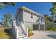 Beautiful two-story coastal home with gray siding, white trim, and an elevated foundation with covered parking at 123 Jungle Rd, Edisto Island, SC 29438