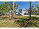 Charming two-story home with a gray exterior, surrounded by beautiful palm trees and lush greenery at 123 Jungle Rd, Edisto Island, SC 29438