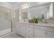 Bright bathroom featuring double vanity, large mirror, and walk-in shower with tiled walls at 129 Brown Swiss Cir, Summerville, SC 29483