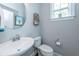 Stylish half bathroom with modern fixtures, a round mirror, and a clean, minimalist design at 133 Alder Cir, Charleston, SC 29412