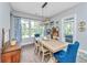 Dining area with a large wooden table, stylish blue chairs, and access to the outdoor space at 133 Alder Cir, Charleston, SC 29412