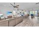 Open concept living area with hardwood floors, neutral tones, ceiling fan, and seamless flow to kitchen at 133 Alder Cir, Charleston, SC 29412