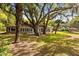 Large backyard with mature trees shading a single-story home at 1405 S Edgewater Dr, Charleston, SC 29407