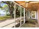 Screened-in porch with stone floors and a view of a sprawling backyard with large trees and water at 1405 S Edgewater Dr, Charleston, SC 29407
