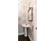 Stylish powder room featuring a pedestal sink, decorative wallpaper, and elegant fixtures at 1405 S Edgewater Dr, Charleston, SC 29407