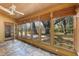 Bright sunroom featuring stone floors, wood ceiling, and a wall of windows overlooking a lush backyard at 1405 S Edgewater Dr, Charleston, SC 29407