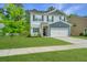 A two-story home with light grey siding, dark blue accents, and a beautiful green lawn at 141 Clydesdale Cir, Summerville, SC 29486
